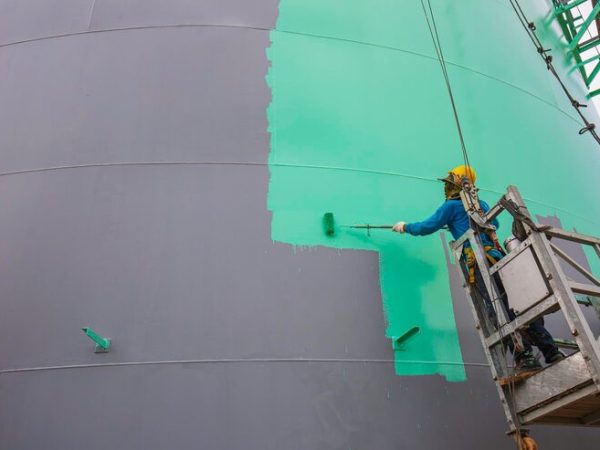 male-worker-takes-cable-car-holding-industrial-painting-brush-used-shell-plate-tank-oil-surface-surface-green-color_478515-6214